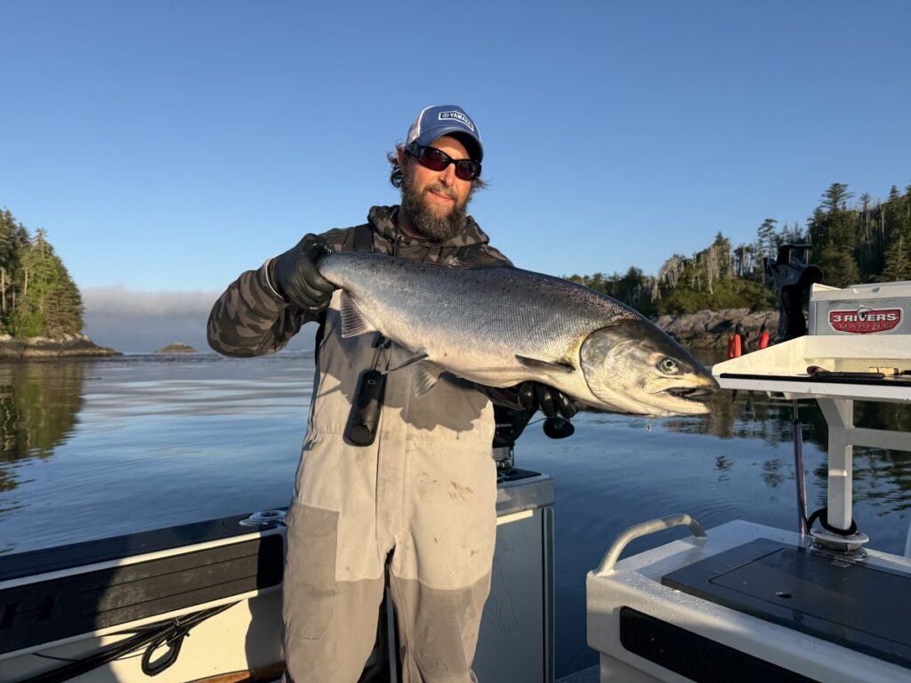 Joe Pyburn holding a big salmon on a boat