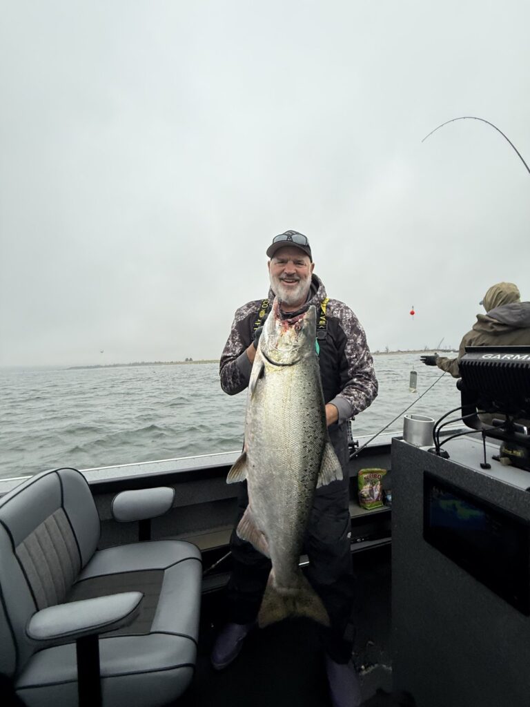 Tom Nelson holding a big chinook salmon on a boat